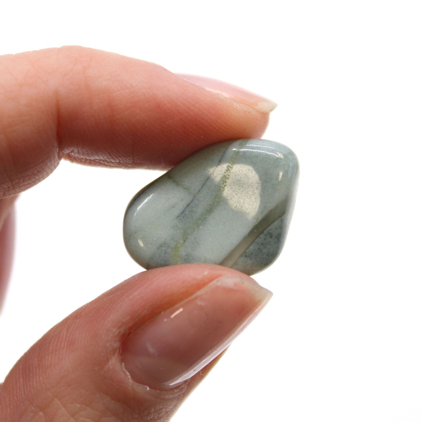 Hand holding a greenish-blue stone against a white background