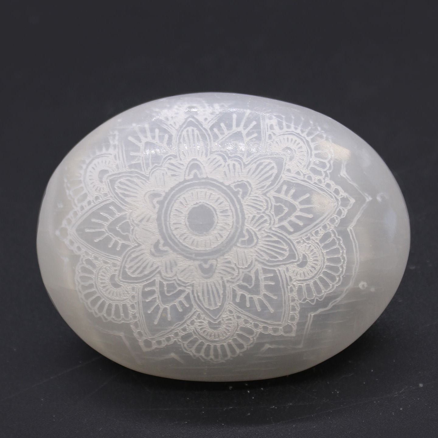 Decorative stone with mandala pattern on a black background