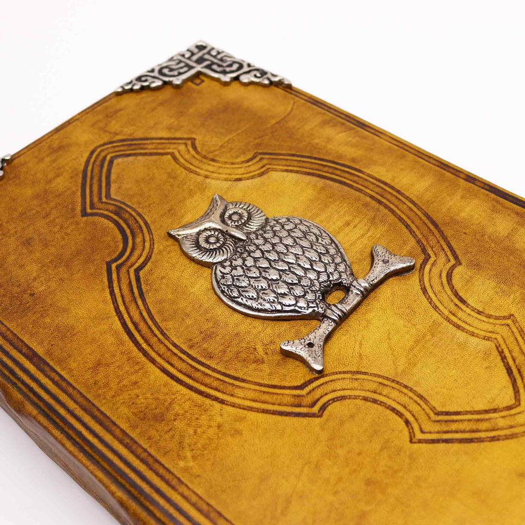 Leather-bound book with an owl emblem on a white background