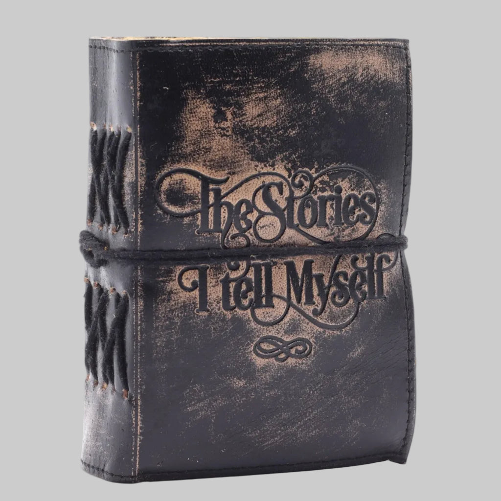 Vintage-style leather-bound book with 'The Stories I Tell Myself' text on a white background