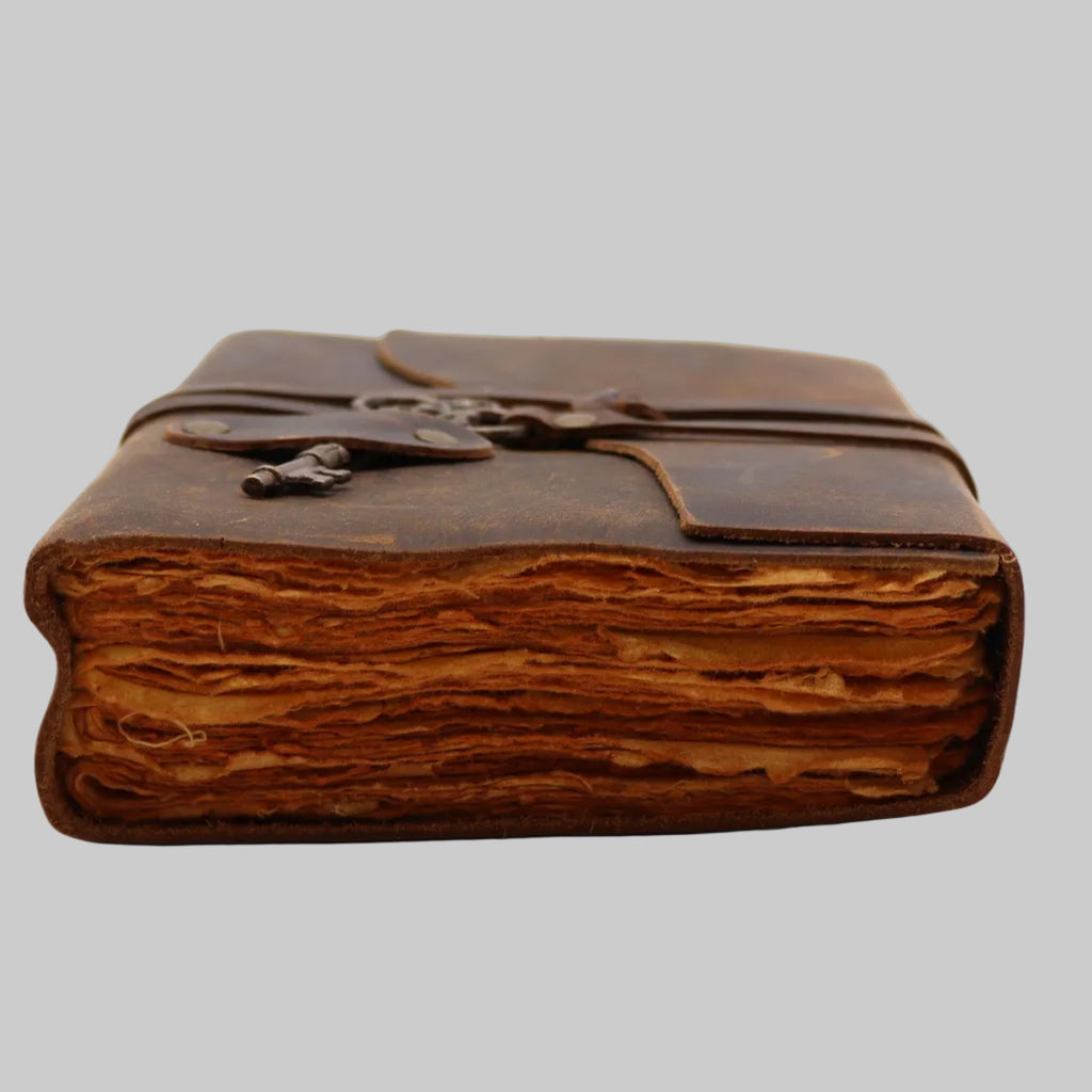 Vintage leather-bound book with a key on a white background