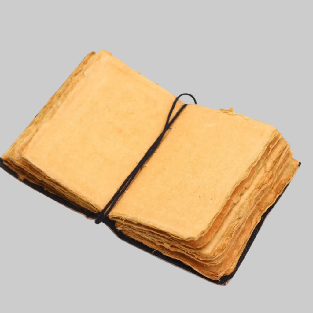 Stack of yellow fabric sheets tied with black string on a white background