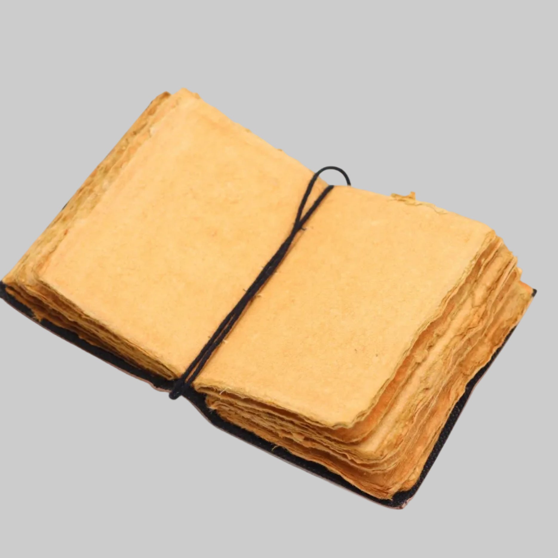 Stack of yellow fabric sheets tied with black string on a white background