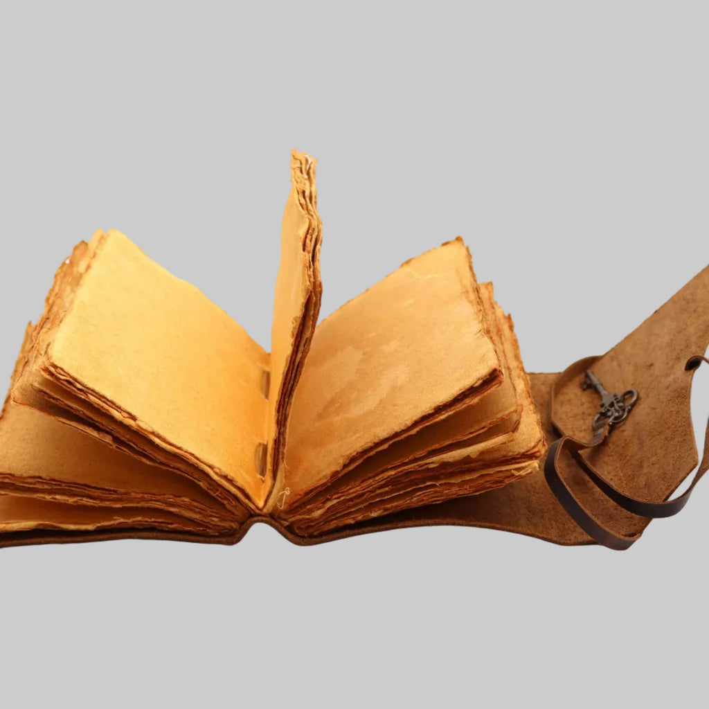 Open leather-bound book with a strap on a white background