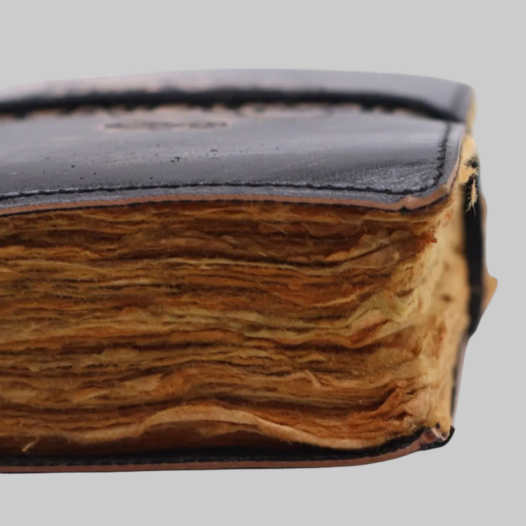 Close-up of an old leather-bound book on a white background