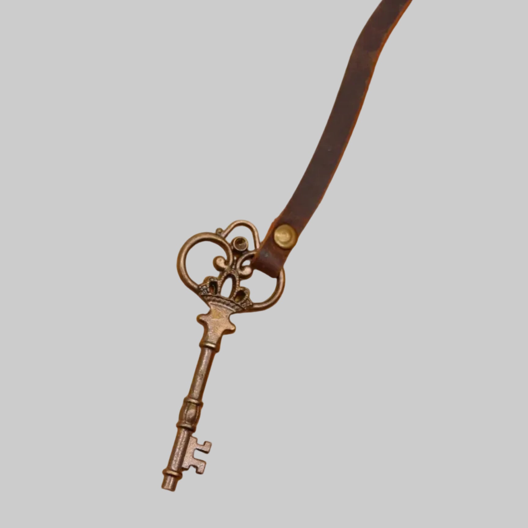 Vintage key pendant on an old book with a white background