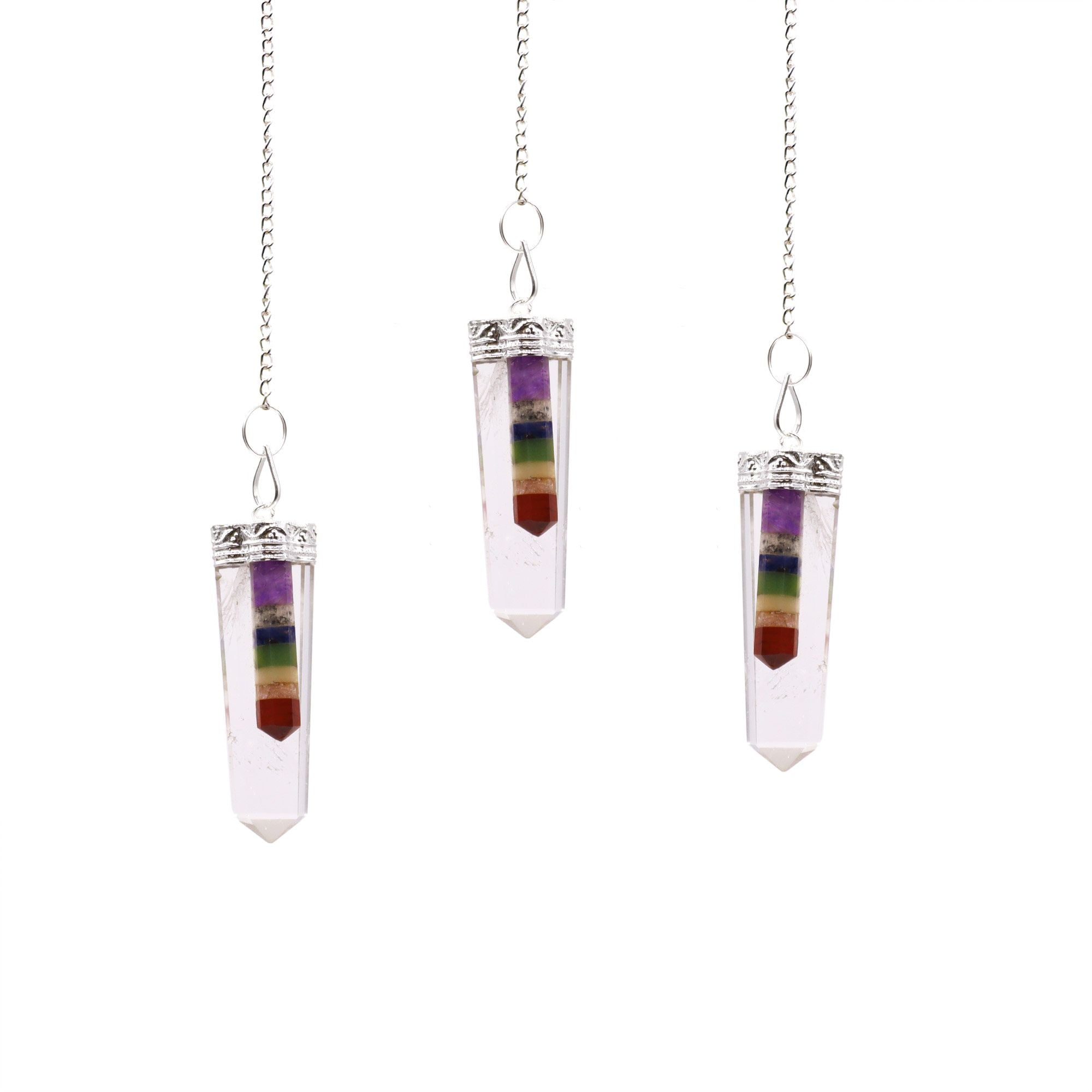 Three chakra crystal pendulums on white background