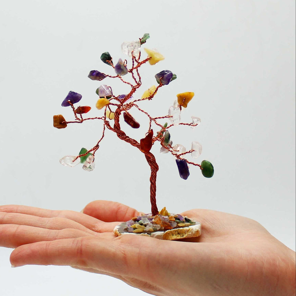 Small crystal tree on a hand against a white background