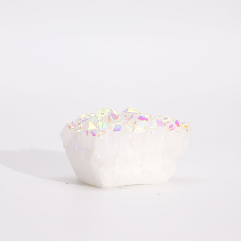 White ceramic heart with colorful glitter on a light gray background