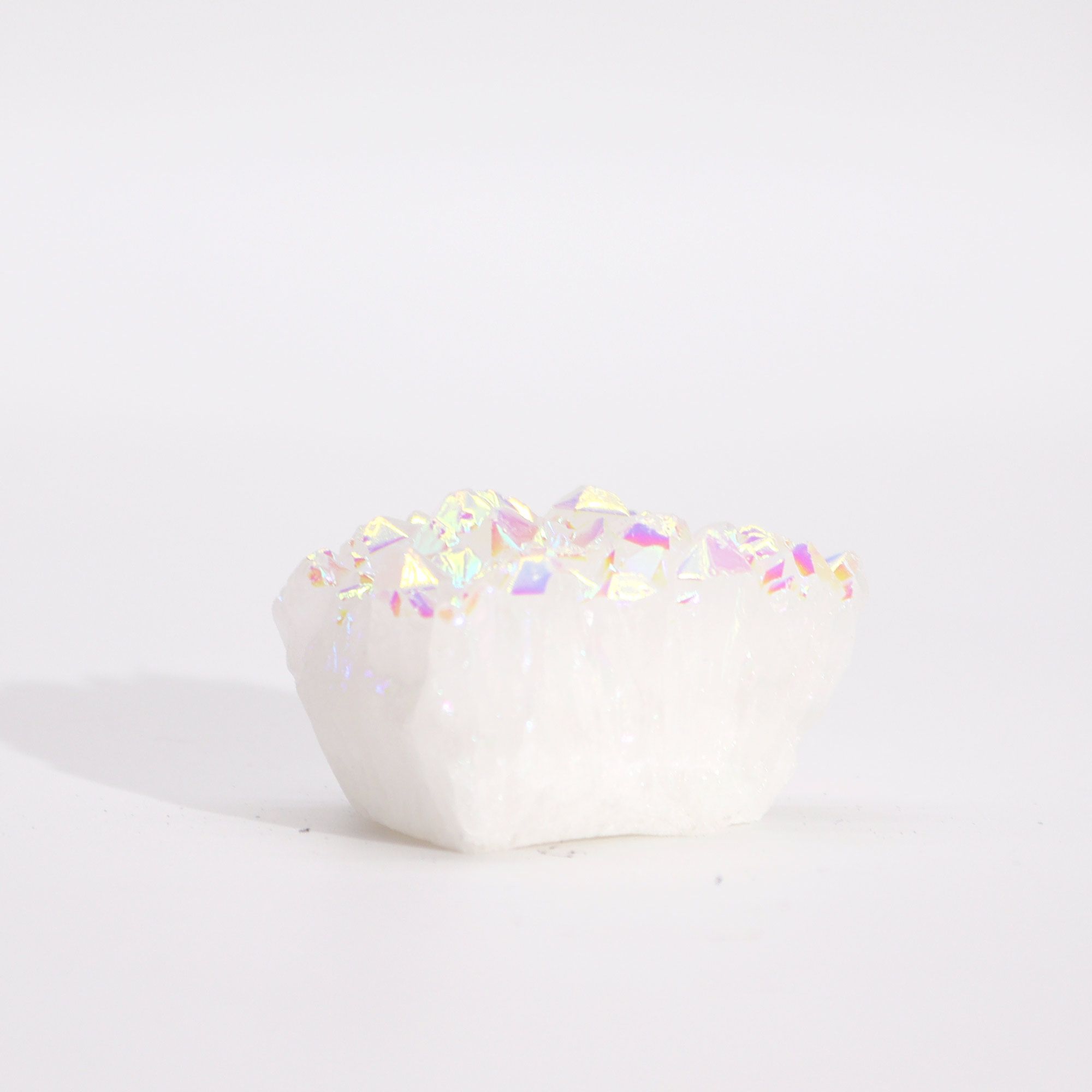 White ceramic heart with colorful glitter on a light gray background