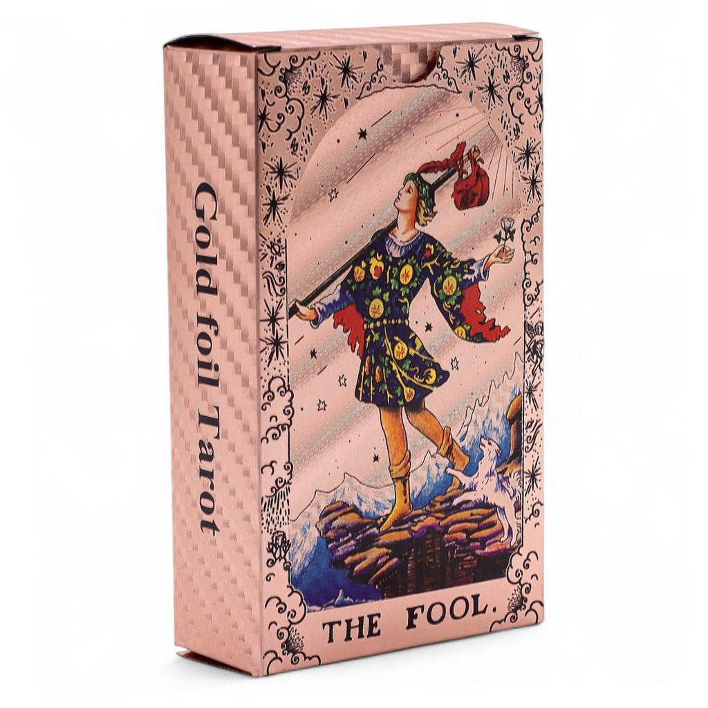Gold foil Tarot card box featuring 'The Fool' with intricate design and text.