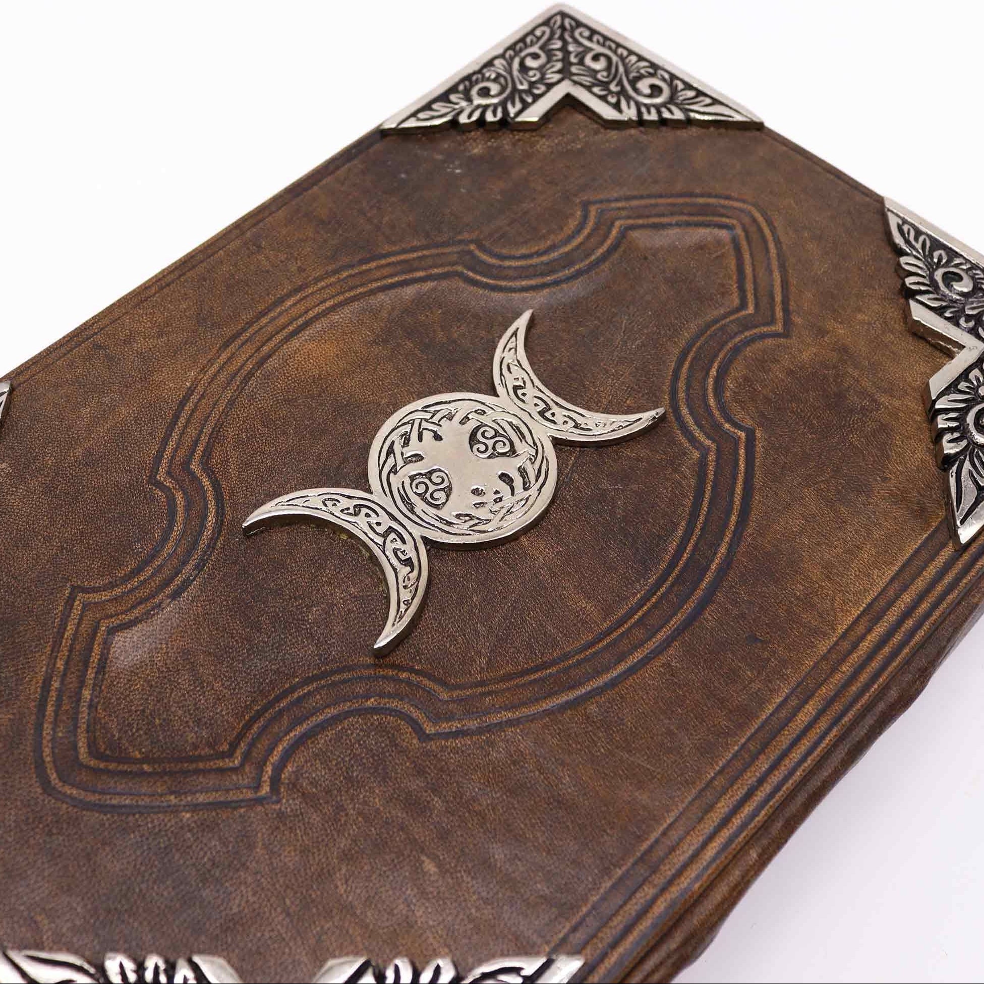 Decorative leather book with silver emblem on a white background