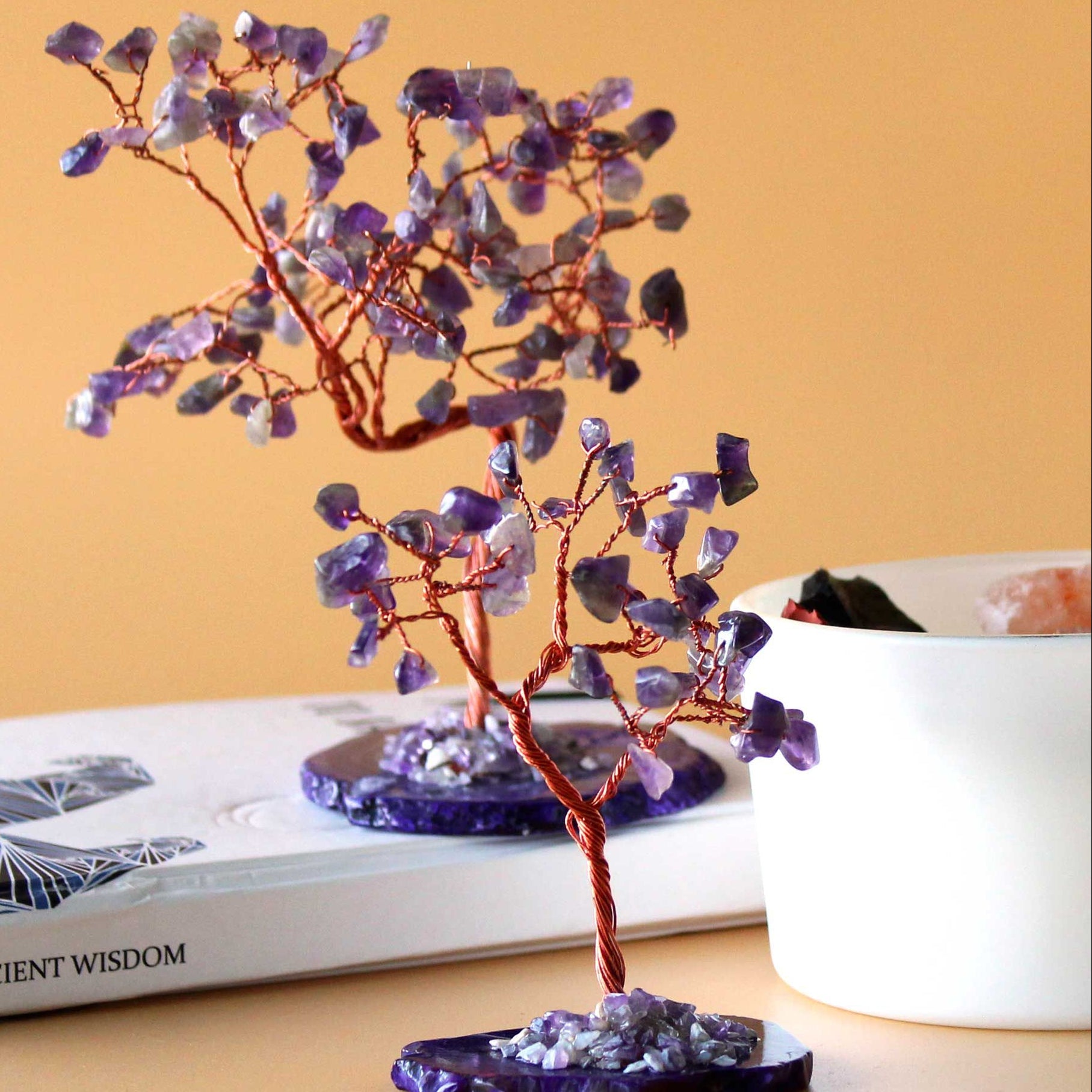 Decorative crystal tree on a table with books and a vase in the background