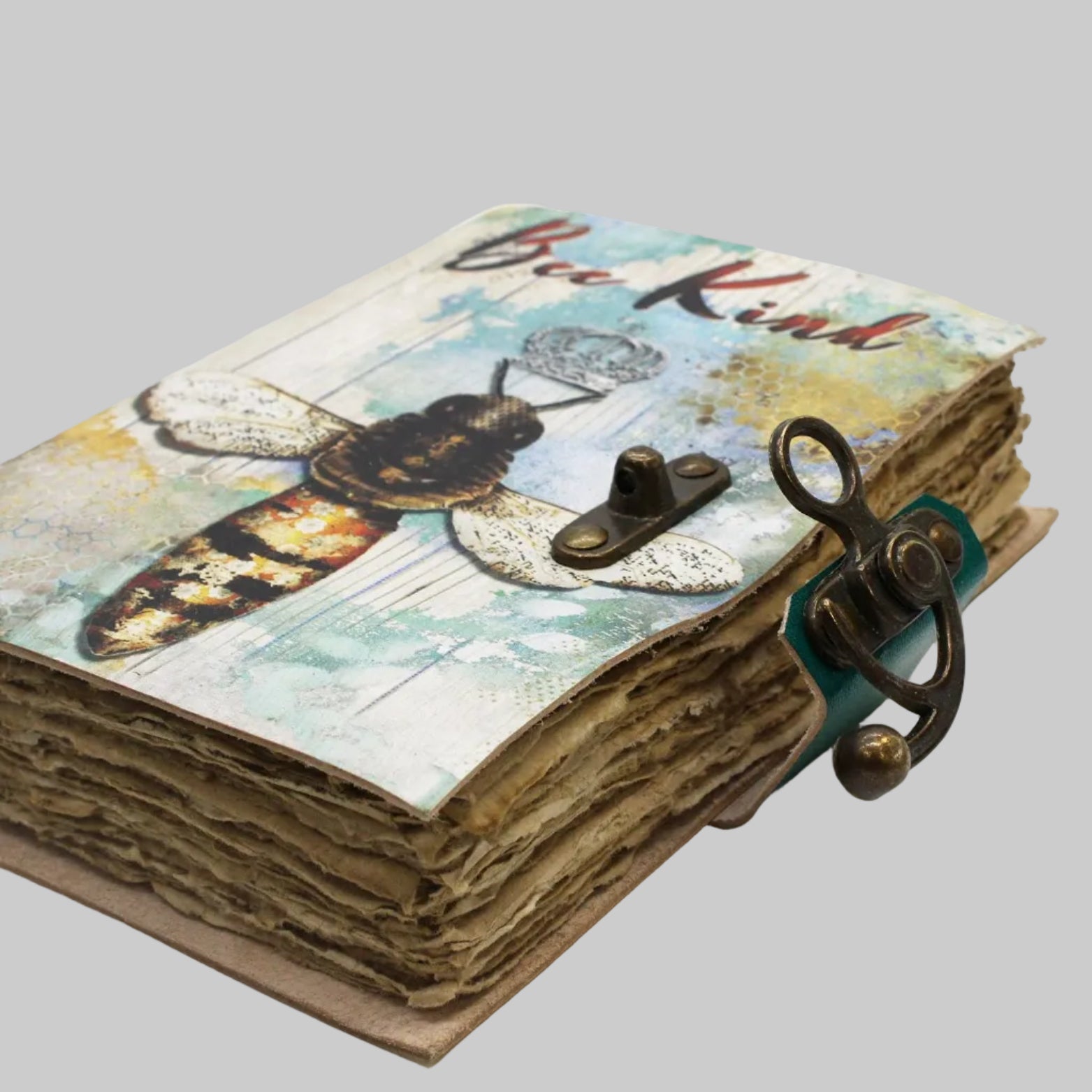 Handmade journal with bee-themed cover and decorative clasp on a white background