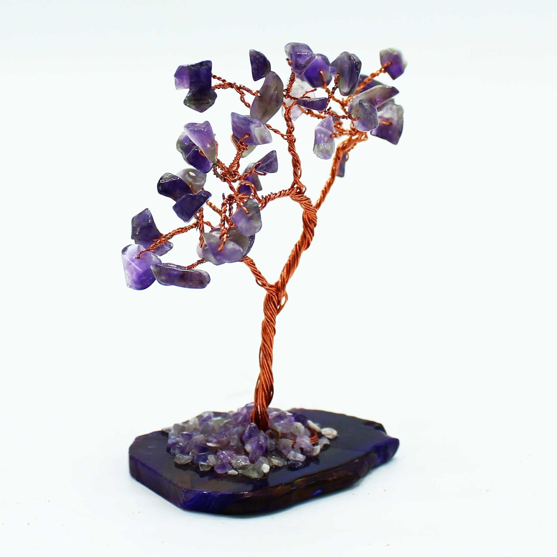 Amethyst crystal tree on a dark base with a white background