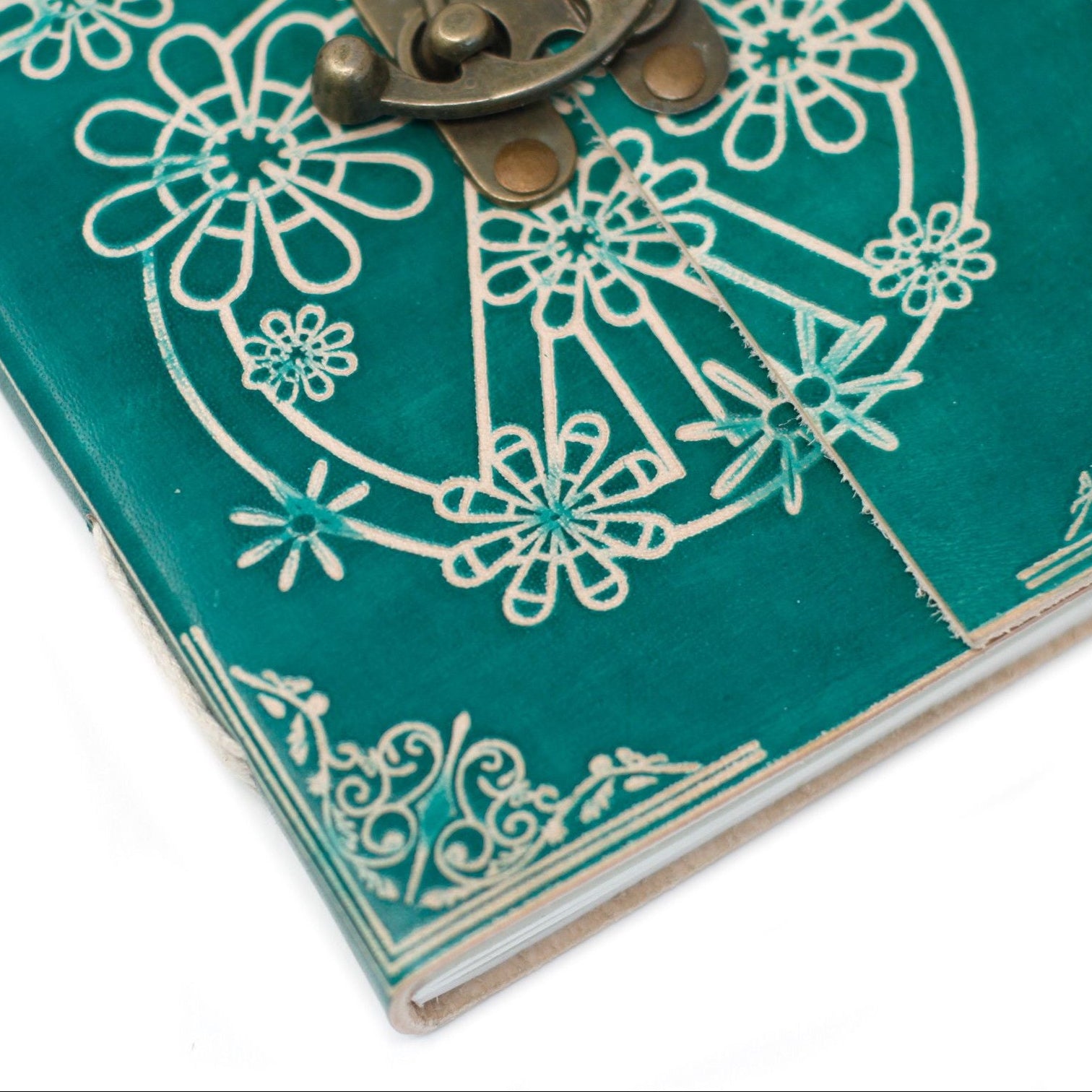Teal notebook with floral patterns and a brass lock on a white background