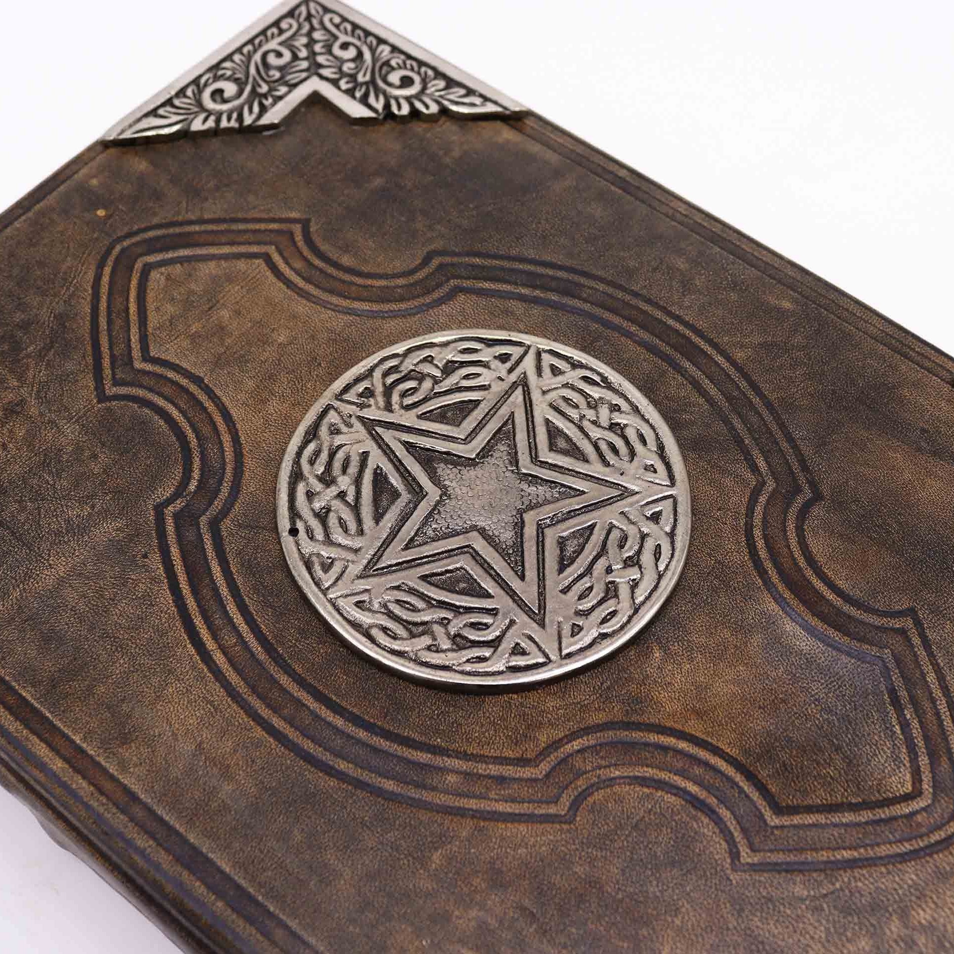Decorative leather book with metallic star emblem on a white background