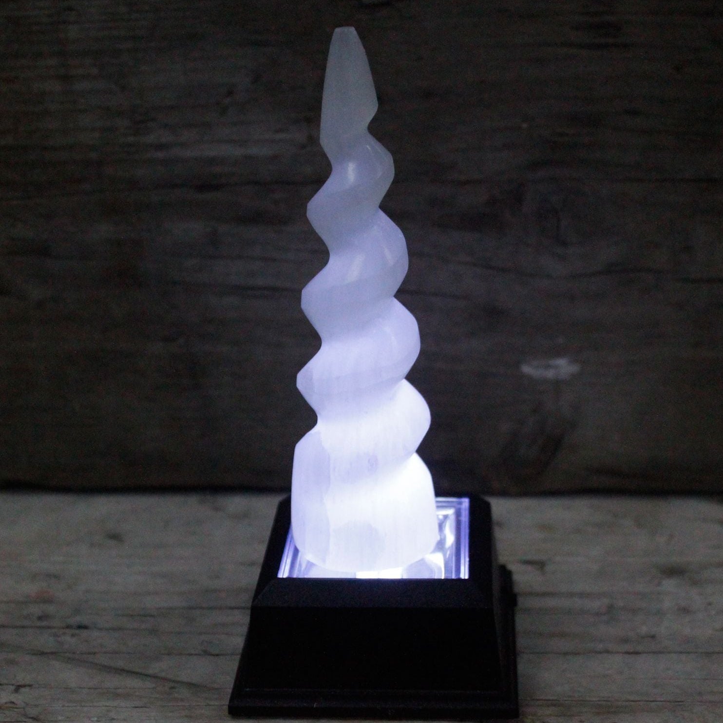 Decorative spiral light on a wooden surface with a dark background