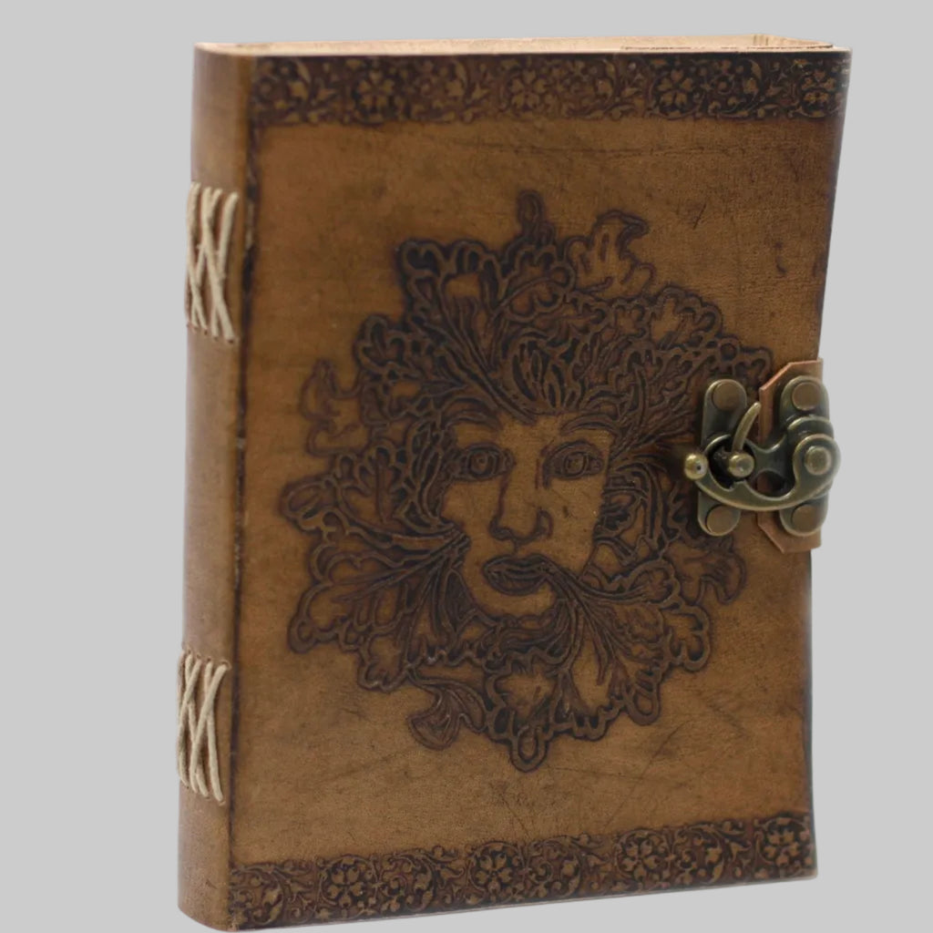 Brown leather journal with embossed face design and metal clasp on a white background
