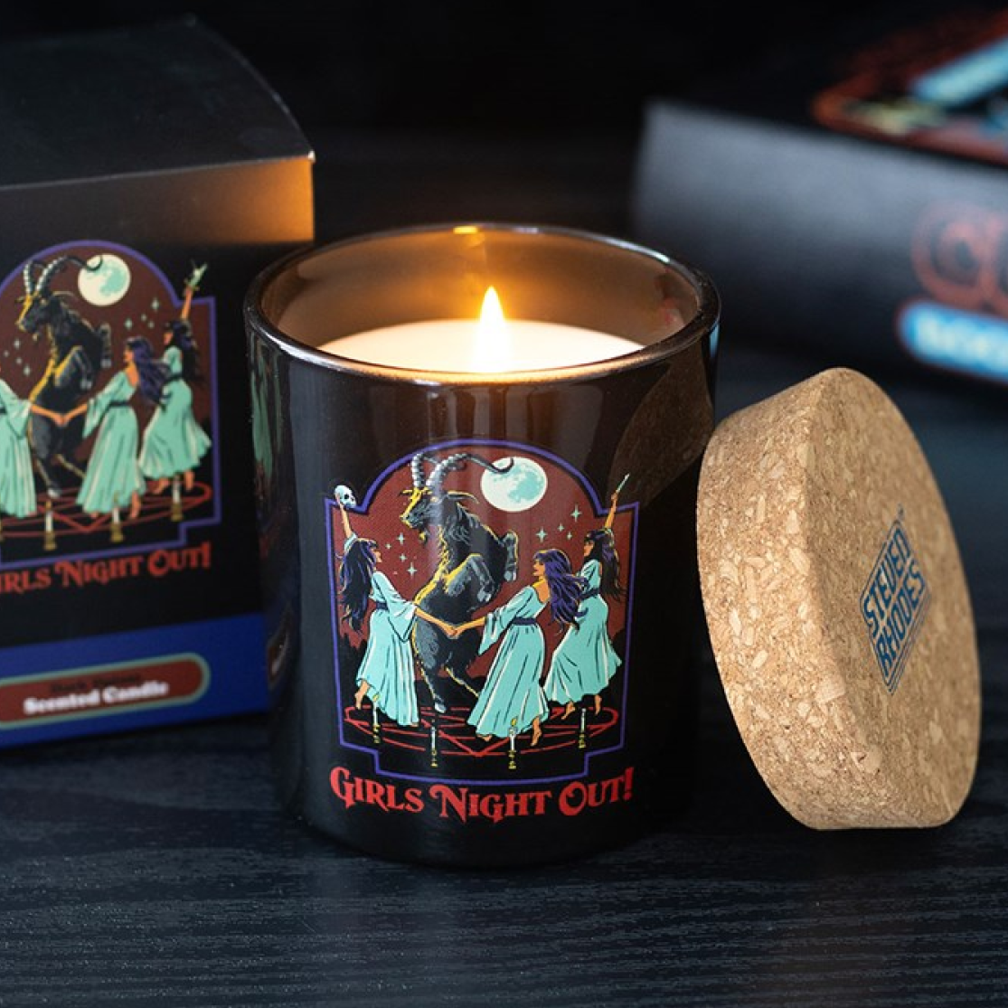 Candle with 'Girls Night Out' design and cork lid on a dark surface